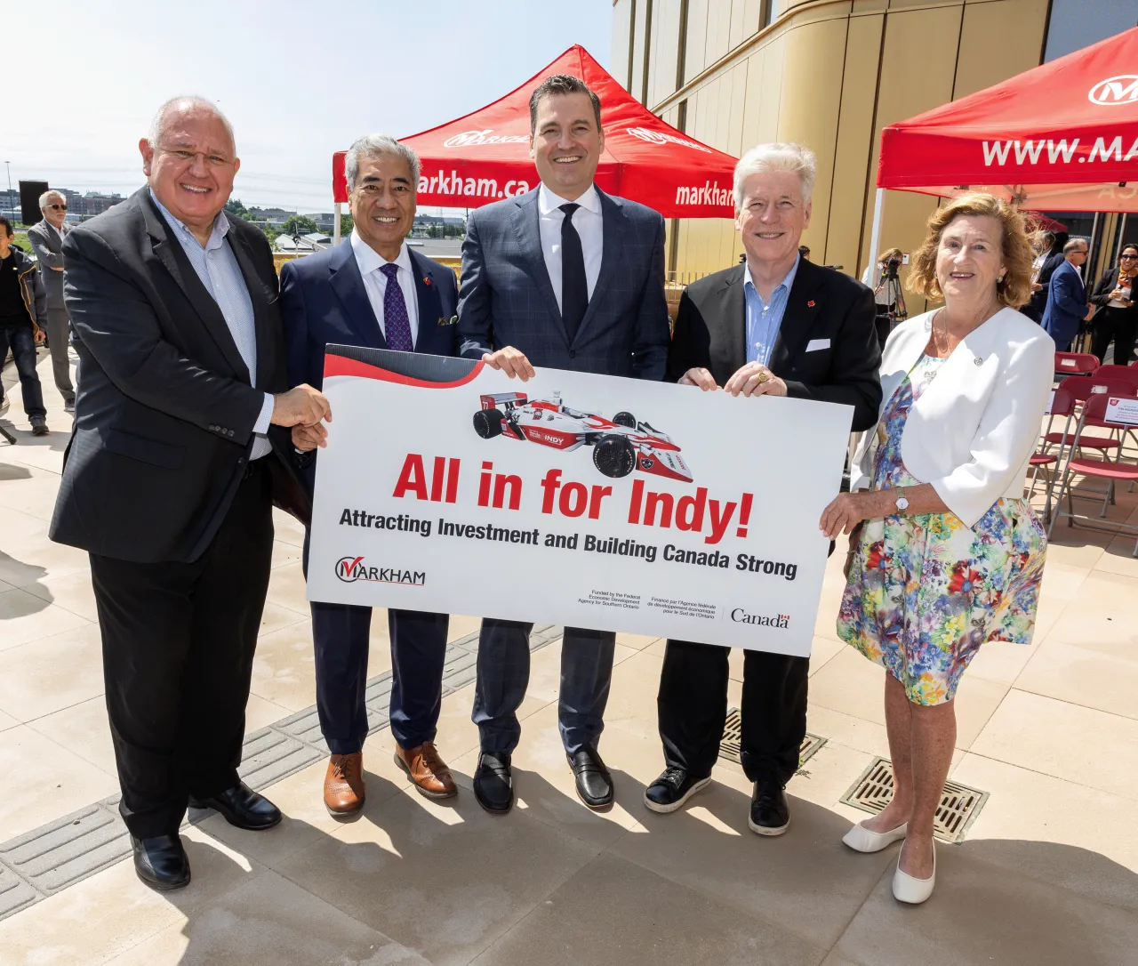 Frank Scarpitti, Michael Ma, Evan Solomon, Tim Hodgson, and Helena Jaczek holding a sign that reads "All in for Indy! Attracting investment and Bulding Canada Strong"