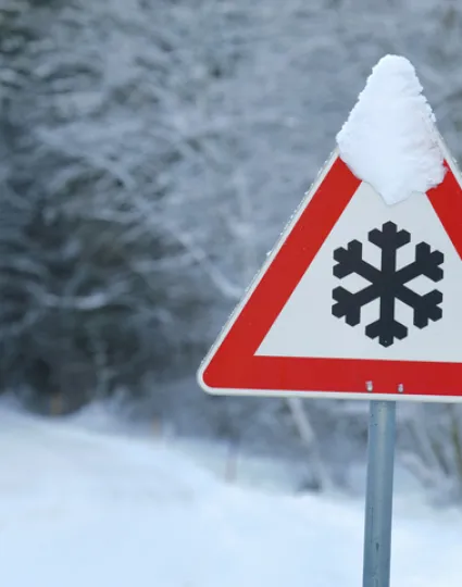Traffic warning sign of ice and snow on road